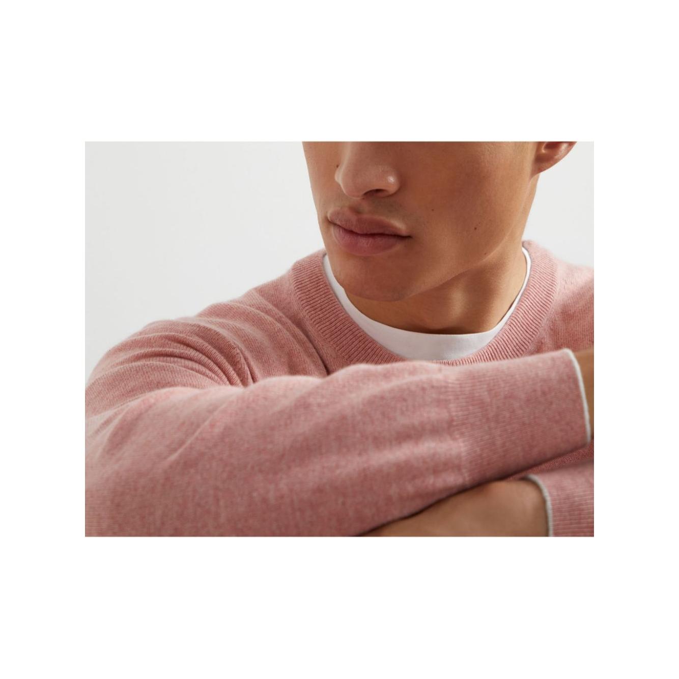 Model wearing Brunello Cucinelli light pink crew neck cashmere sweater with ribbed cuffs and hem.