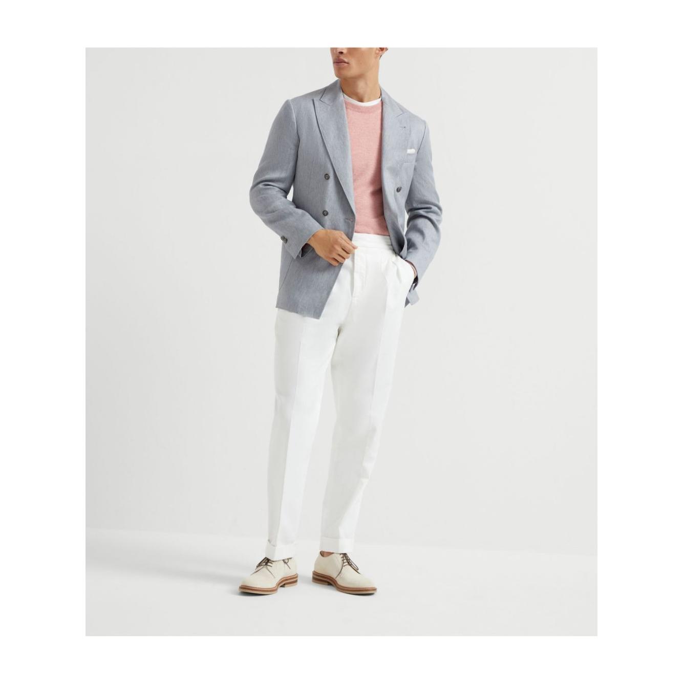 Model wearing a light pink cashmere Brunello Cucinelli sweater with a gray blazer and white pants, showcasing elegant men's fashion.