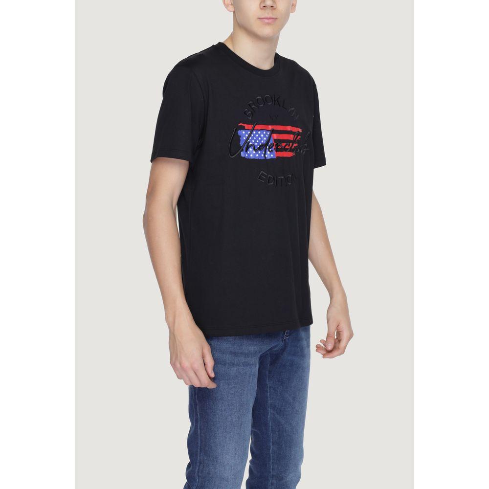 Man wearing Underclub black cotton T-shirt, Spring/Summer collection, USA flag graphic, 100% cotton, paired with blue jeans.