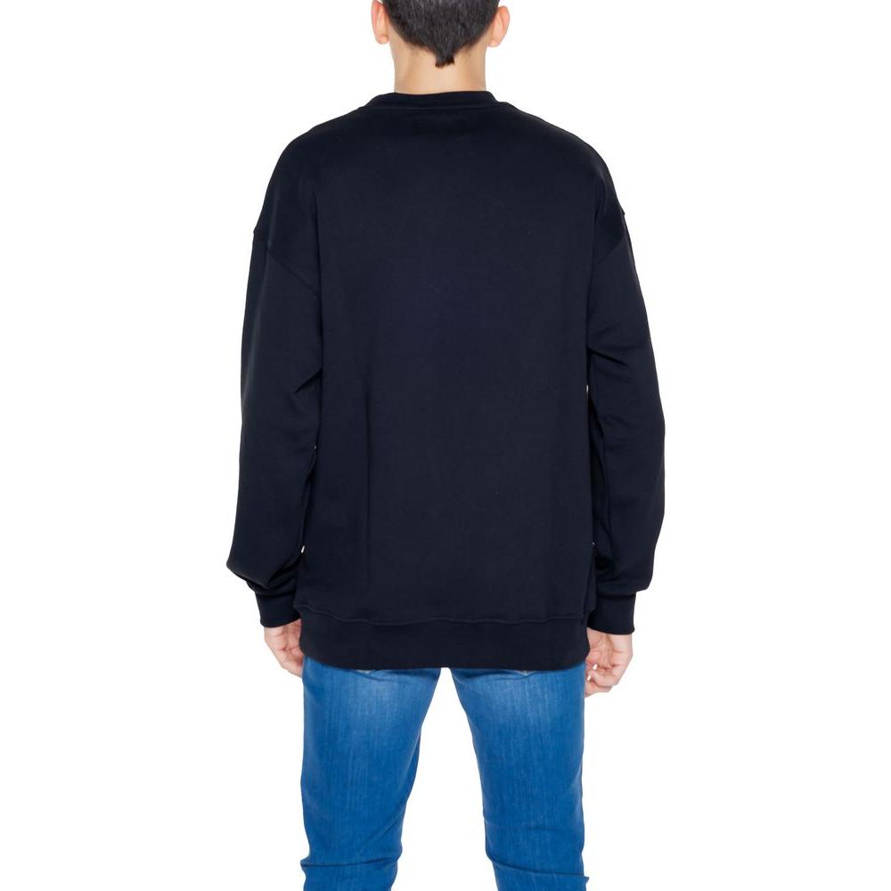 Back view of man wearing Underclub black cotton sweater, hoodless sweatshirt for spring/summer collection.