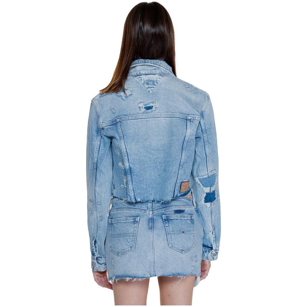 Back view of a woman wearing a light blue Tommy Hilfiger jacket made with recycled cotton, showcasing the denim's distressed style.