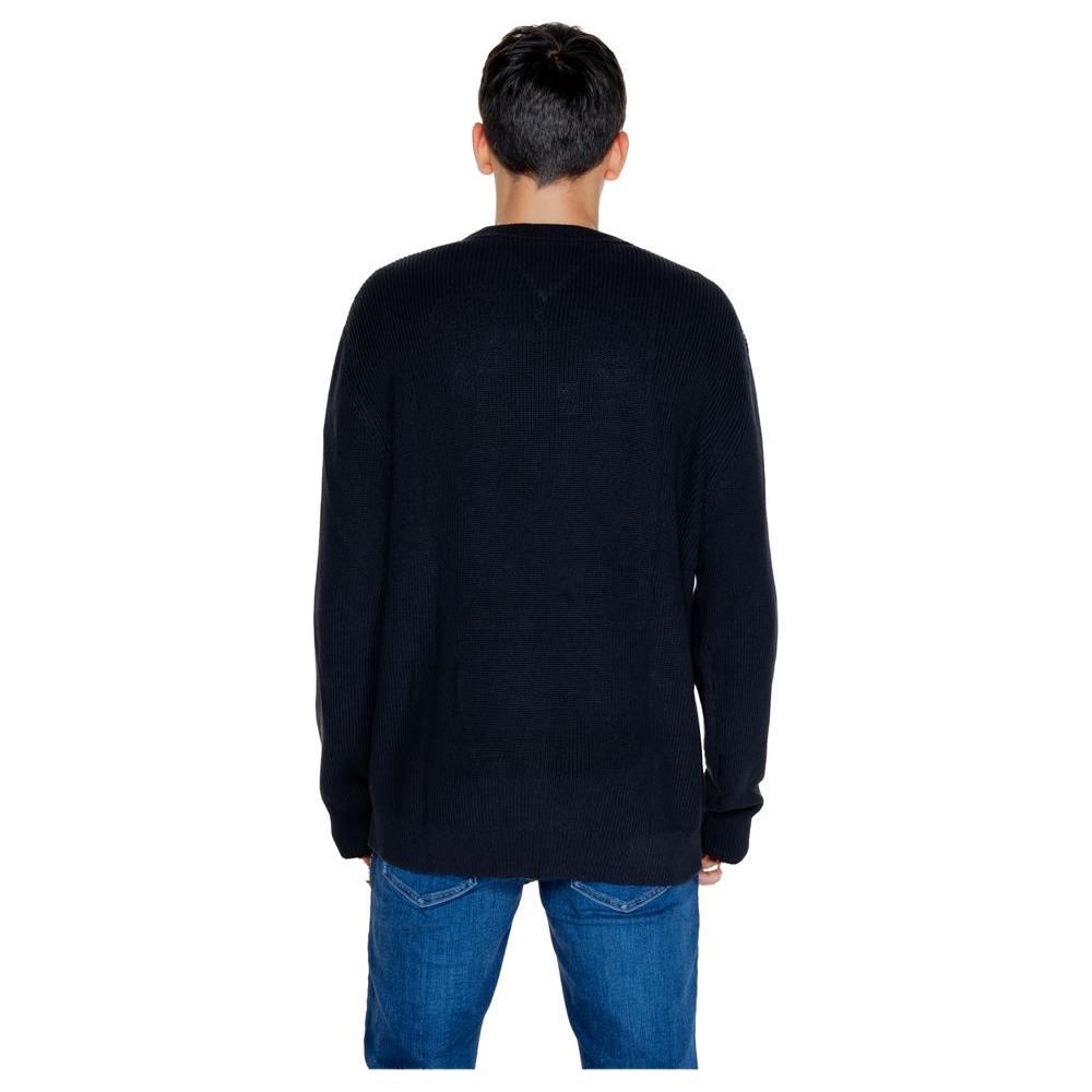Back view of men's black Tommy Hilfiger organic cotton sweater from Autumn/Winter collection, worn with jeans.