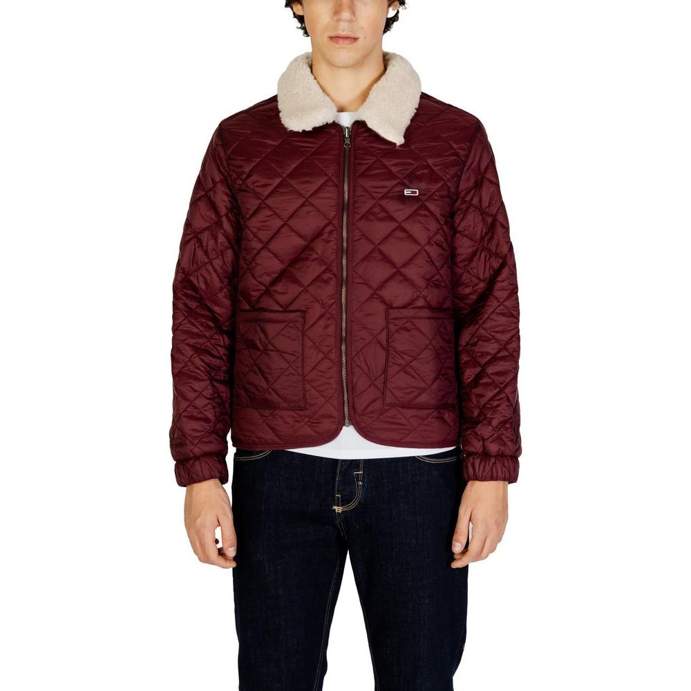 Man wearing a burgundy quilted jacket with a faux shearling collar, front view, hands at sides.