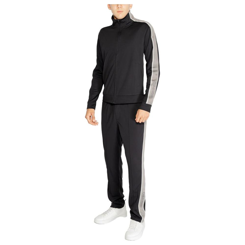 Man wearing Calvin Klein Sport Black Recycled Polyester Sweater and pants, showcasing modern fit and comfort for sports activities.