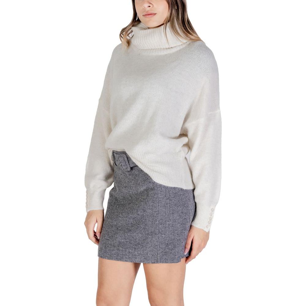 Woman wearing ICHI cream acrylic sweater from fall/winter collection, featuring a cozy turtleneck and long sleeves.