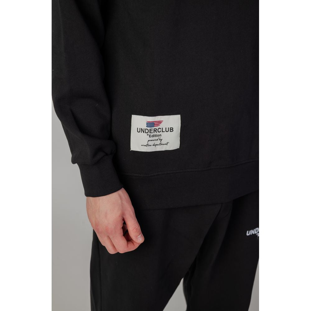 Man wearing Underclub black cotton sweater, autumn/winter collection, showcasing label detail on the side.