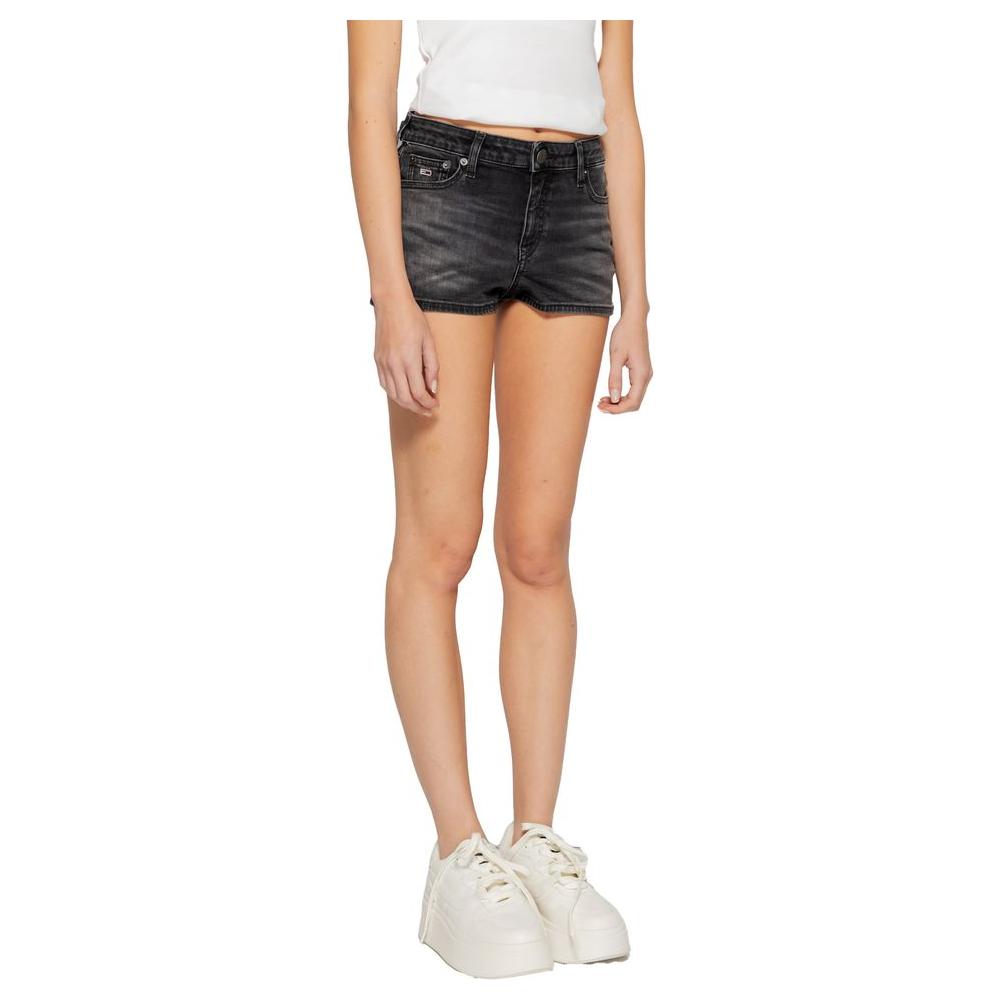 Woman wearing Tommy Hilfiger black recycled cotton shorts from the Spring/Summer collection, paired with white sneakers.