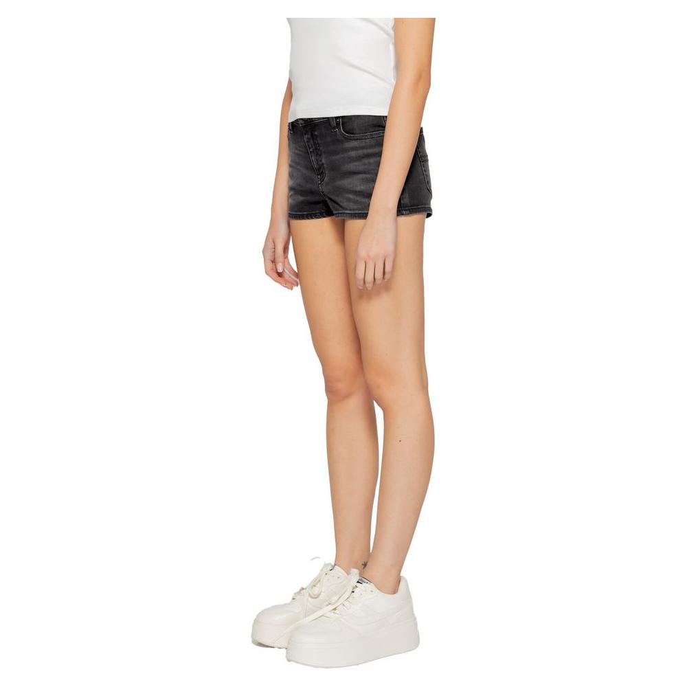 Tommy Hilfiger women's black recycled cotton shorts for Spring/Summer collection, modeled with white sneakers and casual top.
