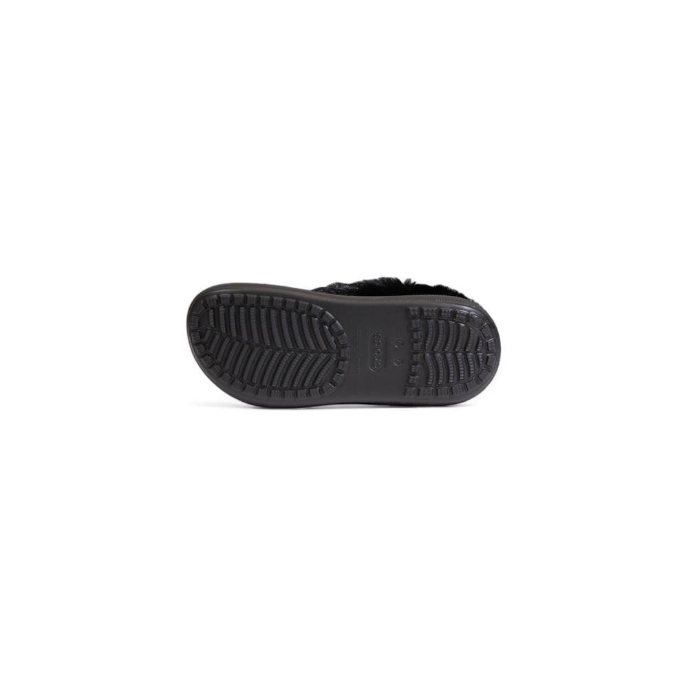 Bottom view of Crocs Furever Crush sandal, showing black tread design with synthetic material and faux fur lining.