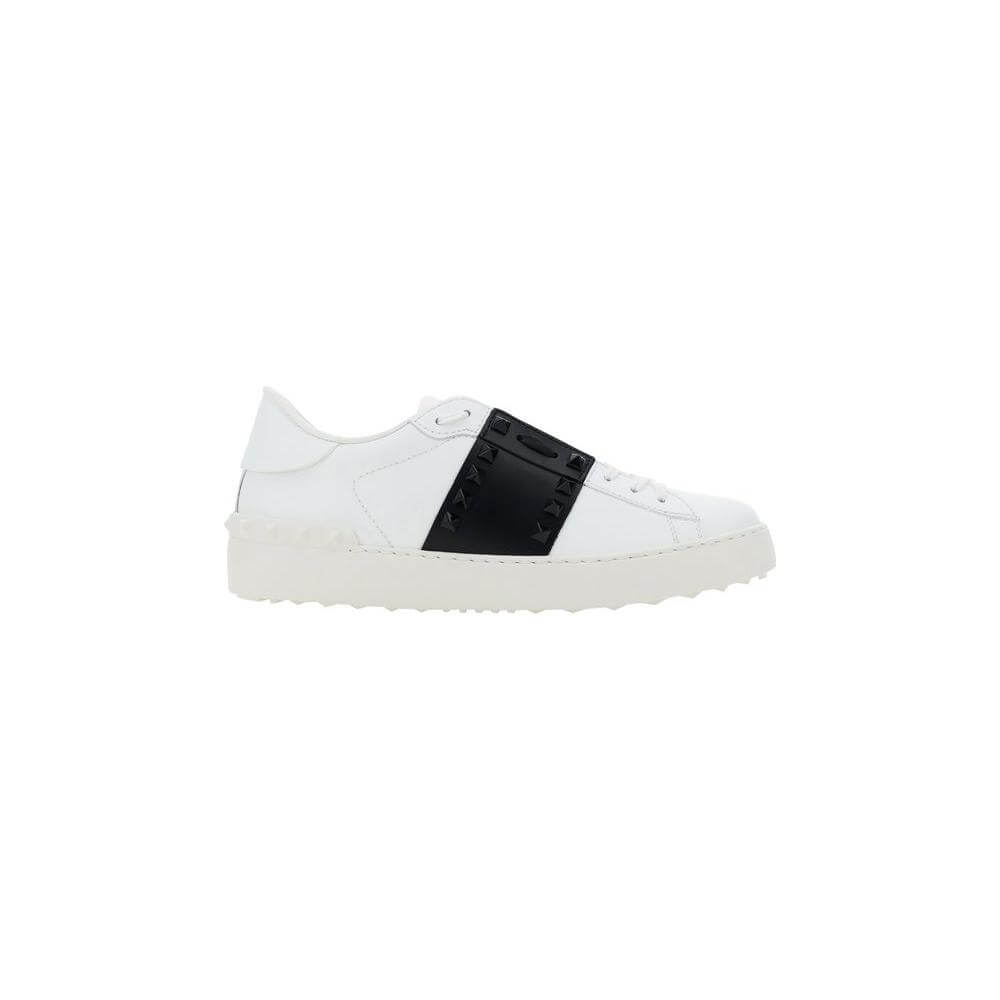 Valentino Garavani Rockstud Open Sneakers in white leather with black band, featuring slip-on design and knurled sole for elegance and comfort.