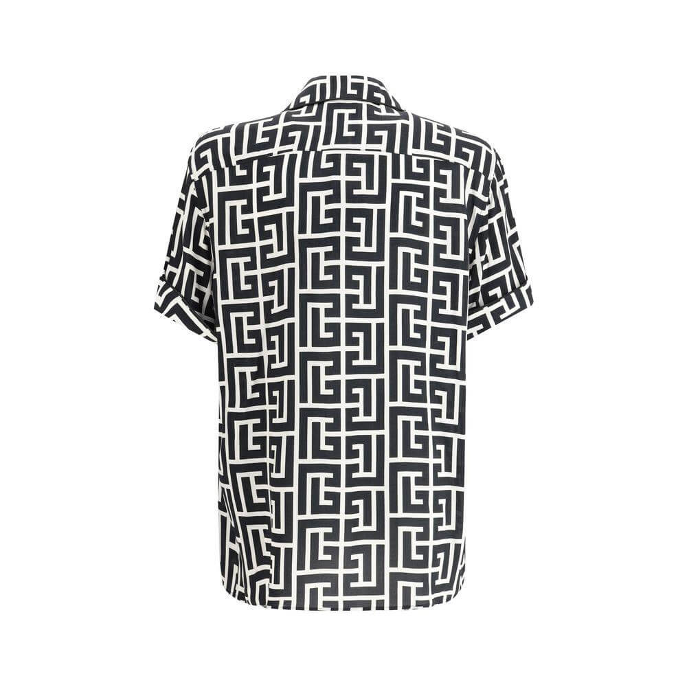 Back view of Balmain shirt with short sleeves, black and white iconic brand logo pattern, classic lapels, and button closure.