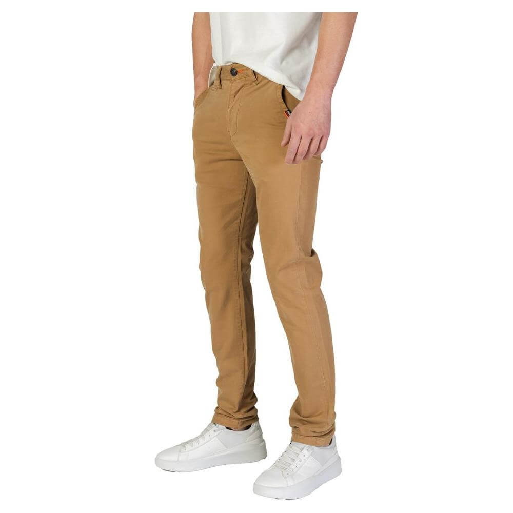 Superdry men's slim beige cotton pants, fall/winter collection, featuring 98% cotton and 2% elastane, modeled with white sneakers.