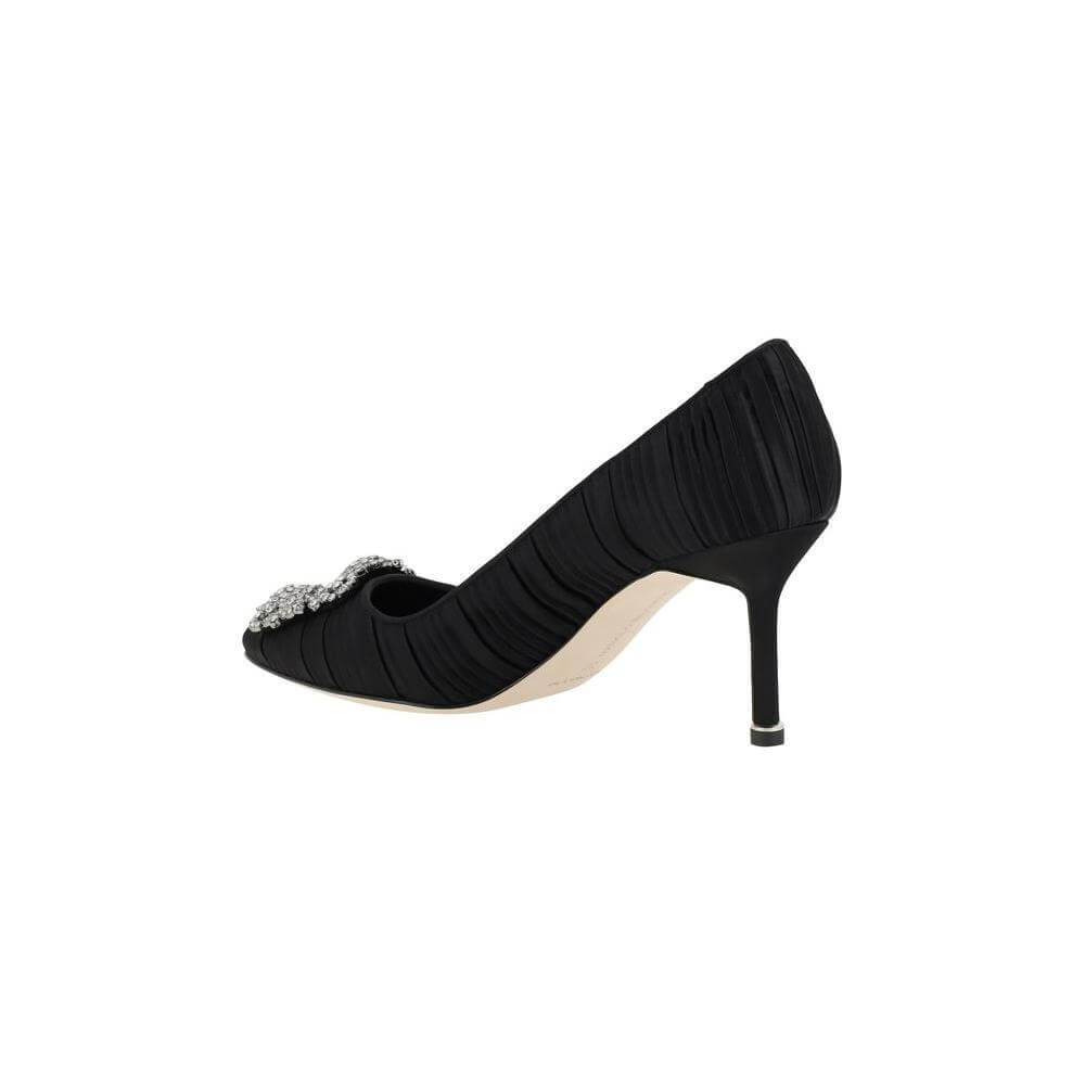 Side view of black Manolo Blahnik Hangisi Pump with Swarovski crystal buckle and stiletto heel. Elegant silk satin shoe.