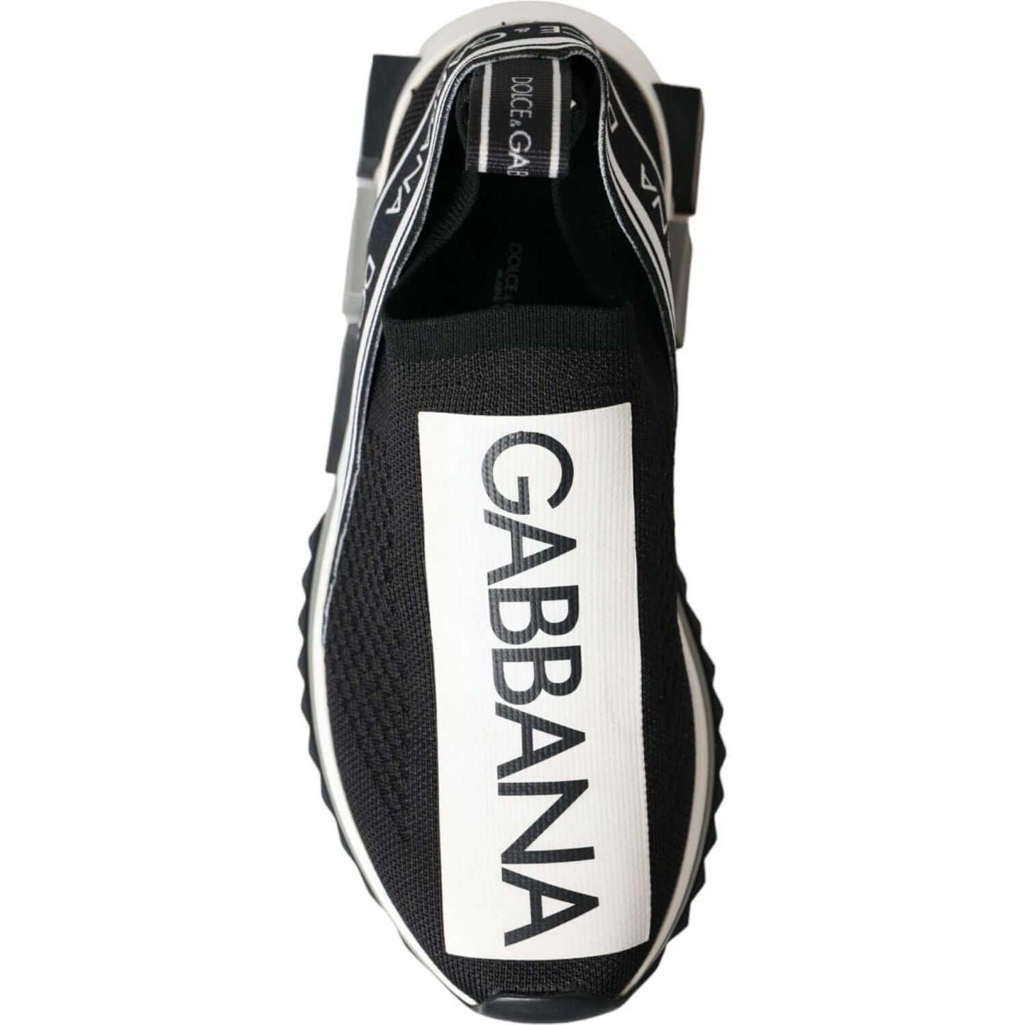 Dolce & Gabbana Sorrento sneaker, black and white slip-on with logo print, top view showing fabric pull strap and rubber sole.