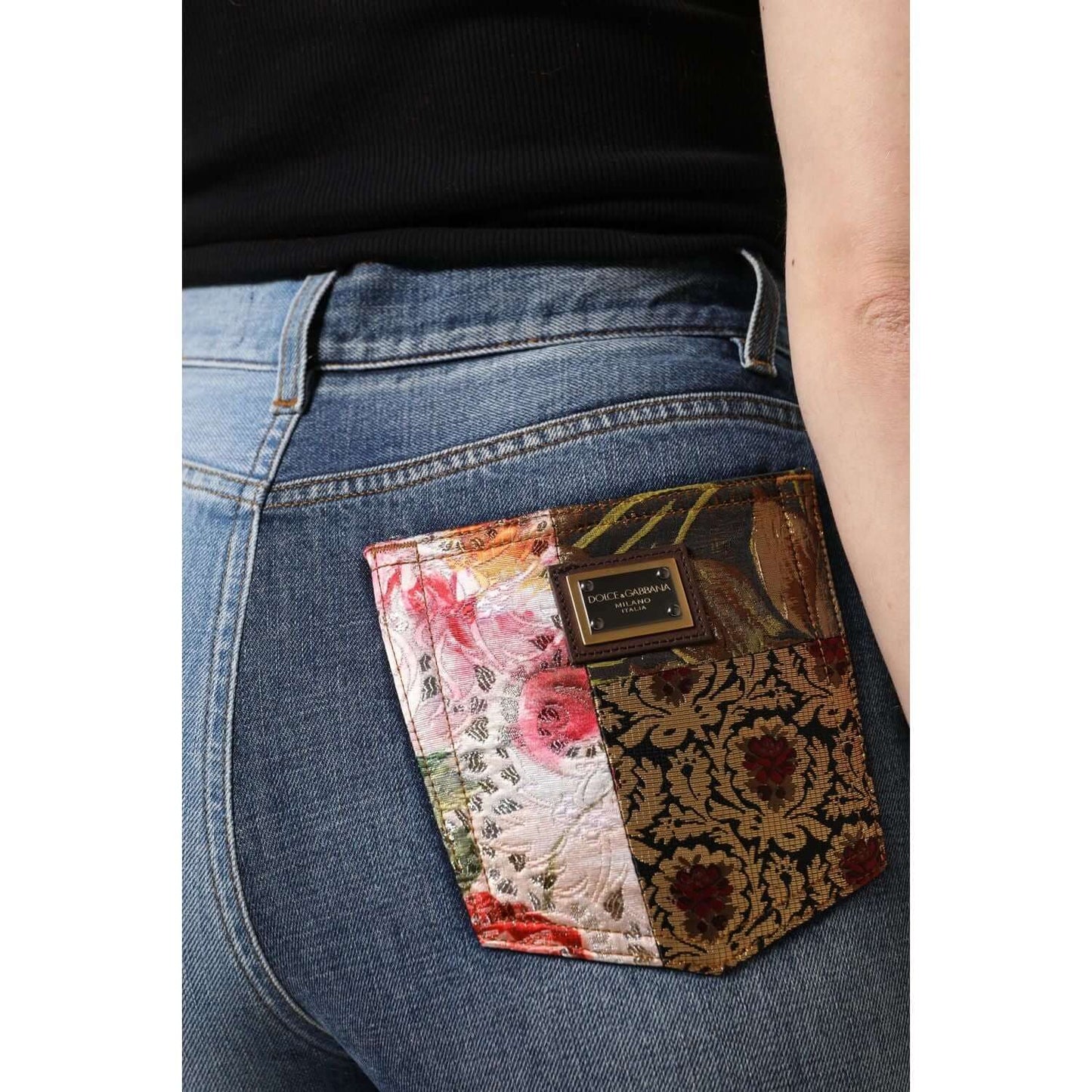 Close-up of Dolce & Gabbana multicolor patchwork high waist denim jeans with floral jacquard and logo details on back pocket.