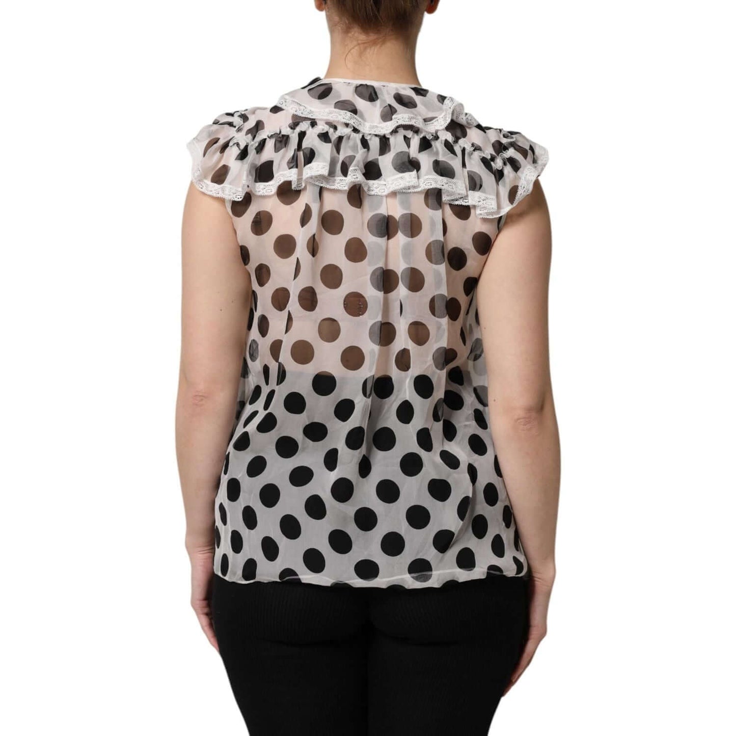 Dolce & Gabbana sleeveless blouse with black polka dots on white fabric, back view showcasing ruffled collar and high-quality craftsmanship.