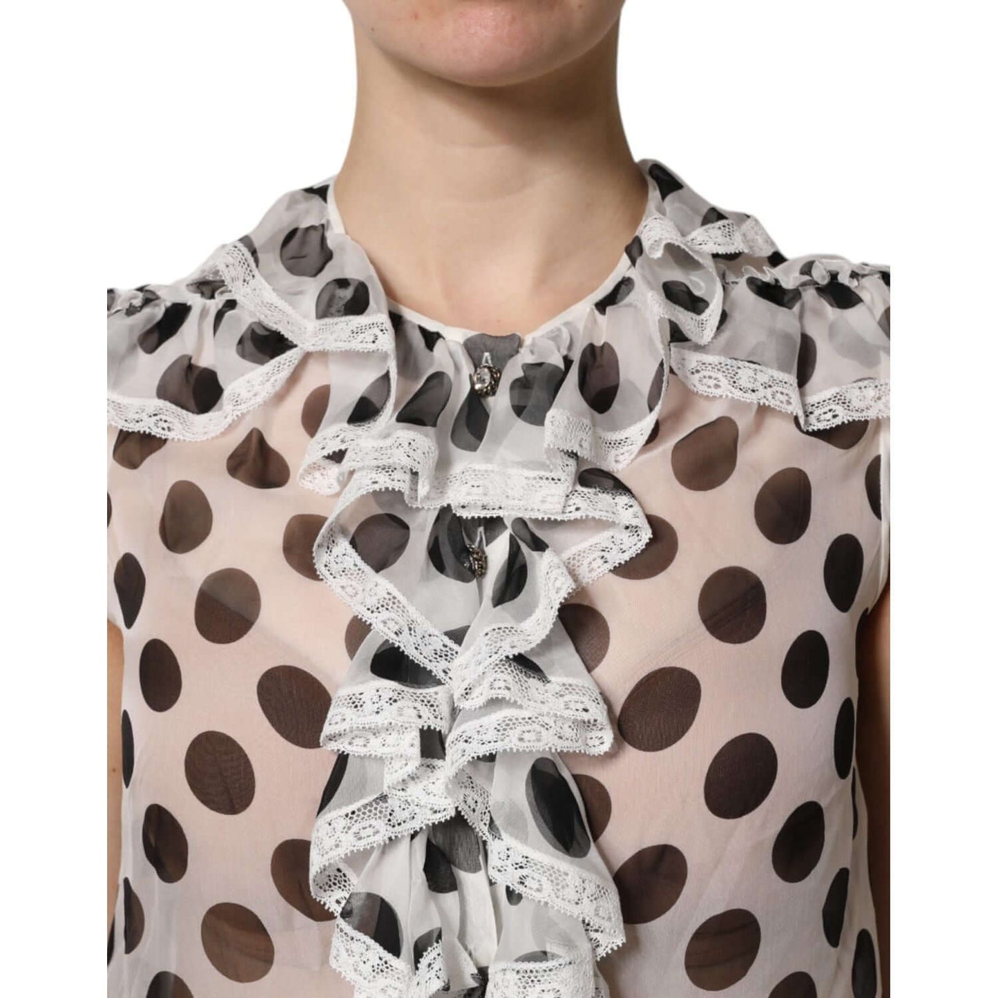Dolce & Gabbana polka dot sleeveless top with ruffle detail, white and black silk cotton blend, close-up of crew neck design.