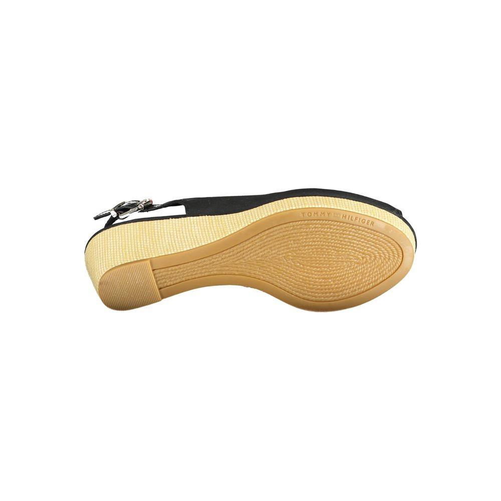 Sole view of Tommy Hilfiger black leather women's sandal with ankle buckle, showcasing iconic logo and textured sole design.