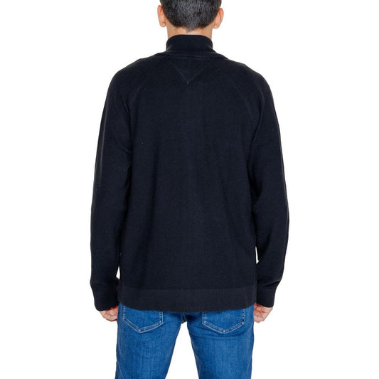 Back view of a black 100% cotton Tommy Hilfiger cardigan, men's autumn/winter collection, paired with blue jeans.