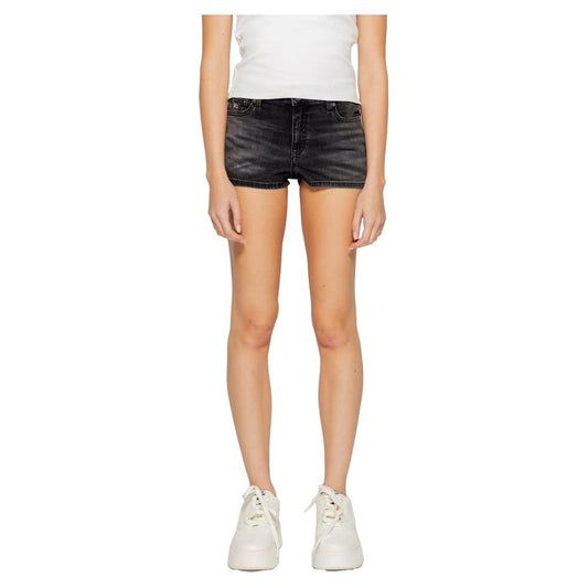 Woman wearing Tommy Hilfiger black recycled cotton shorts, part of spring/summer collection, showcasing sustainable fashion design.